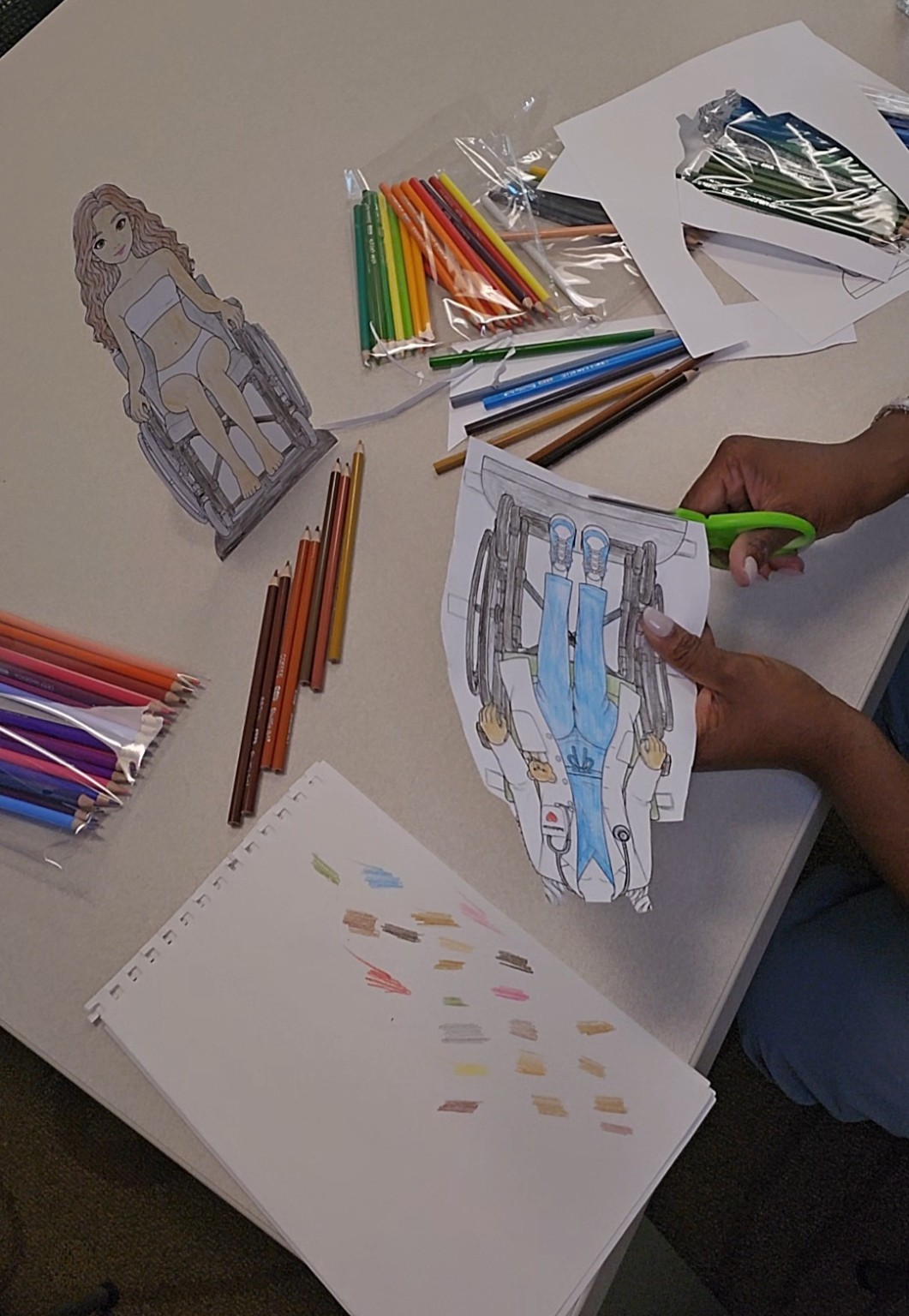 Coloring and cutting a paper-doll character.