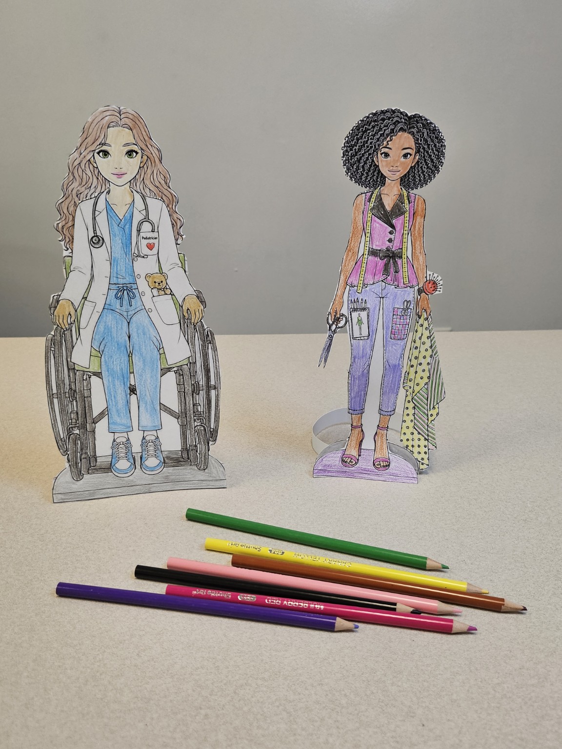 Two finished paper-doll characters.